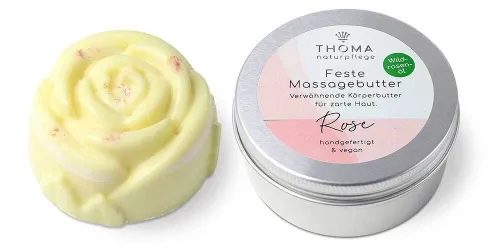Gelbe feste Massagebutter in Rosenform neben silberner Dose mit weiß-rosafarbener Aufschrift Feste Massagebutter Rose, verwöhnende Körperbutter mit Wildrosenoel, handgefertigt und vegan von der Naturseifen Manufaktur Uckermark.