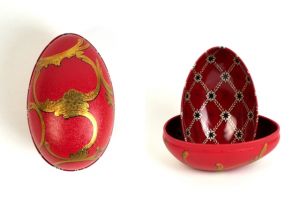 Zwei Metalldosen im Fabergé-Stil, eine geschlossen in Rot mit goldenen Ornamenten und geschwungenen Verzierungen, die andere geöffnet mit rotem Innenmuster und goldenen Details, von der Naturseifen Manufaktur Uckermark.