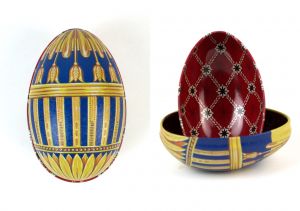Zwei Metalldosen im Fabergé-Stil, eine geschlossen in Blau mit goldenen Tulpenmotiven und filigranen Verzierungen, die andere geöffnet mit rotem Innenmuster und goldenen Ornamenten, von der Naturseifen Manufaktur Uckermark.