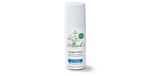 Abbildung einer Augencreme -Hellwach- von Thoma. Die Verpackung zeigt eine grüne Gestaltung mit floralen Elementen und dem Hinweis -Kran-beöl-. Die Augencreme ist in einem weißen Airless-Spender mit silbernem Deckel verpackt und verspricht eine erfrische
