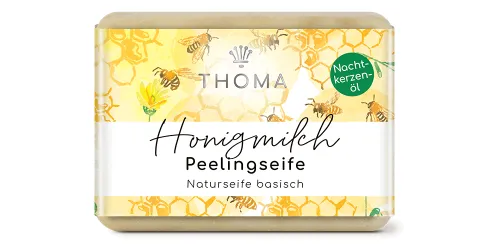 rechteckige, beige-braune Seife mit gelber Verpackung und Aufschrift Honigmilch, Peelingseife mit sanftem Peeling Effekt von der Naturseifen Manufaktur Uckermark.