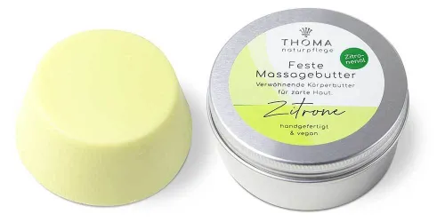 Runde, gelbe feste Massagebutter in Zitronenform neben silberner Dose mit weiß-gelber Aufschrift Zitronen Massagebutter, erfrischende und sinnliche Körperbutter mit Zitronenoel, handgefertigt und vegan von der Naturseifen Manufaktur Uckermark.