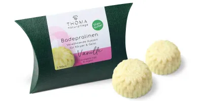 Badepralinen mit Sheabutter - VANILLE Zwei cremefarbene Badepralinen vor dunkelgrüner Verpackung mit weißer Aufschrift Badepralinen Vanille, handgefertigt und vegan mit Sheabutter von der Naturseifen Manufaktur Uckermark.