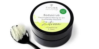 Body Scrub mit Zitronenöl- vegan Runde, schwarze Dose mit weiß-gelber Aufschrift Bodyscrub Zitrone, Feuchtigkeitspelling mit Meersalz und Zitronenoel, handgefertigt und vegan von der Naturseifen Manufaktur Uckermark.