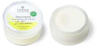Offene Dose mit weißer Deocreme und geschlossenem Deckel mit Aufschrift Zitrone, Deocreme Zitrone von der Naturseifen Manufaktur Uckermark.