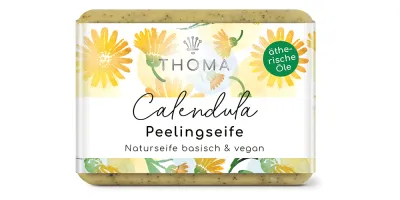 rechteckige, gelblich-braune Seife mit blumiger Verpackung und Aufschrift Calendula, Peelingseife mit Kraeutern von der Naturseifen Manufaktur Uckermark.