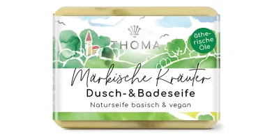 rechteckige, cremefarbene Seife mit grüner Verpackung und Aufschrift Maerkische Kraeuterseife, Dusch und Badeseife mit Sheabutter von der Naturseifen Manufaktur Uckermark.