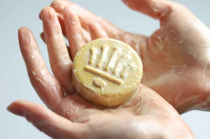 Hände mit feincremigem, sanftem Schaum unseres festen Shampoos